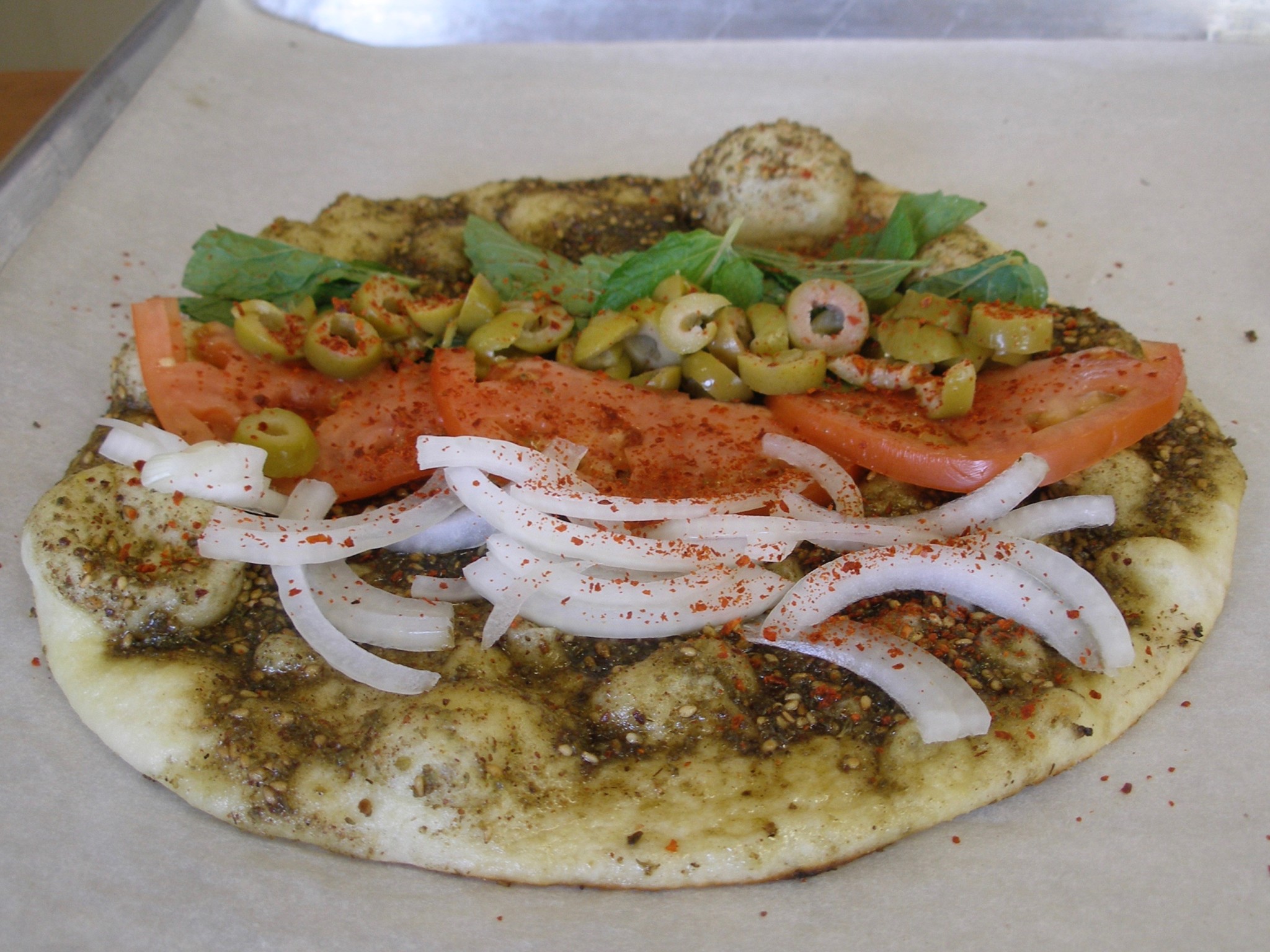 Manaiesh Sandwich ($2) is truly special, and shockingly affordable, a za’atar dusted flatbread lined with mint leaves, tomatoes, green olives and crispy raw onions.